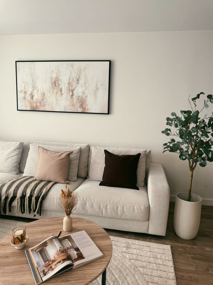 Elegant modern living room with neutral decor and artistic elements.