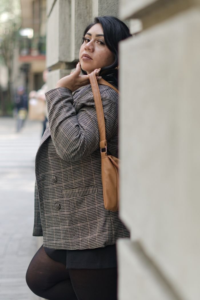 Confident woman posing outdoors against an urban backdrop in Mexico City.